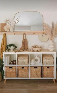 a white shelf with baskets and mirrors on it