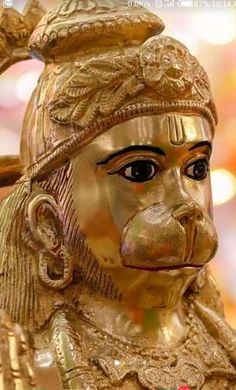 a golden statue of a monkey with a hat on it's head