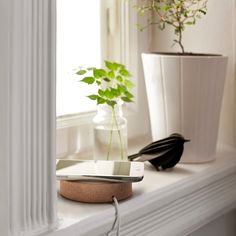 a cell phone is plugged into an outlet on a window sill