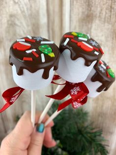 two chocolate covered lollipops with christmas decorations on them