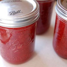 three jars filled with red liquid sitting on top of a table