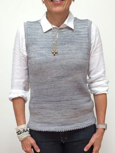 an older woman standing in front of a white wall with her hands on her hips