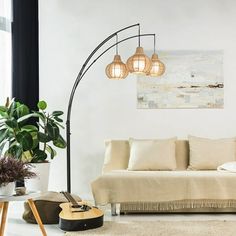 a living room with a white couch and three lights on the floor next to a window