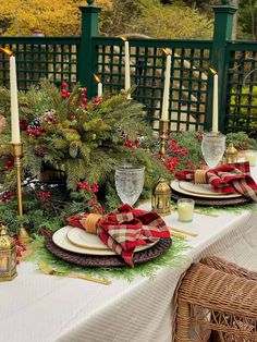 the table is set with plaid napkins and place settings for christmas dinner guests to enjoy