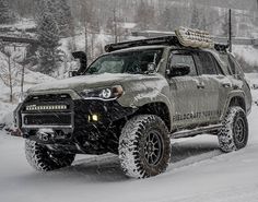 a truck is driving through the snow with skis on it's headlamps