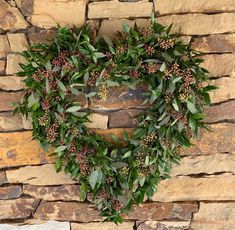 a heart shaped wreath on a stone wall