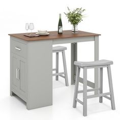 a kitchen table with two stools next to it and a wine bottle on the counter