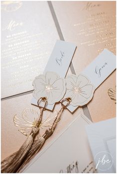 the wedding stationery is laid out on top of each other with flowers in them