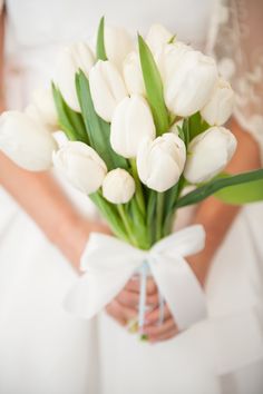 a bride holding a bouquet of white tulips