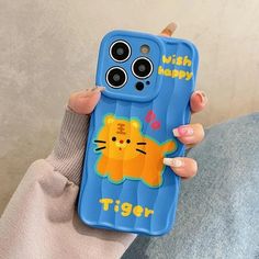 a woman holding up a phone case with a cartoon tiger on the front and bottom