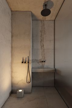 an empty bathroom with a shower head and two lights on the wall next to it