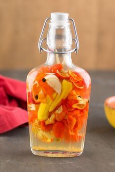 a glass bottle with flowers in it next to a bowl