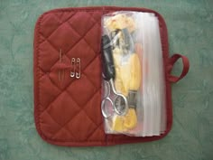 a red case with scissors and other items in it