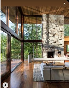 a living room filled with furniture and a fire place in front of a stone fireplace