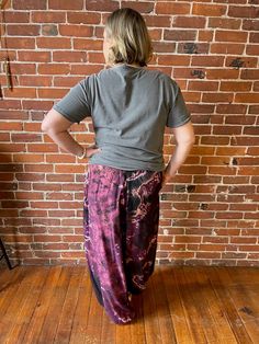 a woman standing in front of a brick wall with her back turned to the camera