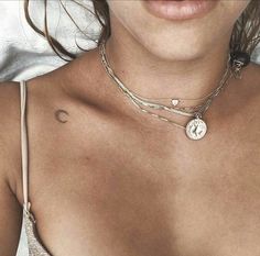 a close up of a woman wearing a necklace with a heart and cross on it