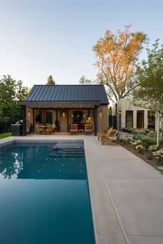 a house with a swimming pool in the middle of it and an outdoor dining area next to it