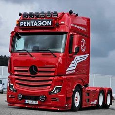 a red semi truck parked in a parking lot