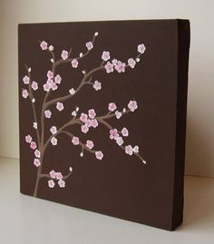 a painting with pink flowers painted on the side of a brown box that is sitting on a table