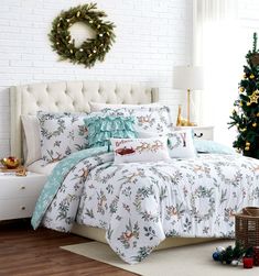 a christmas themed bed in a bedroom with white brick walls and wooden floors, decorated for the holiday season