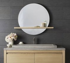 a bathroom vanity with a round mirror above it