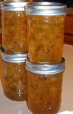 four jars filled with food sitting on top of a table