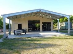 a car is parked in front of a building with a carport attached to it