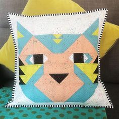 a cat pillow sitting on top of a couch