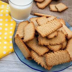 some cookies are on a plate next to a glass of milk