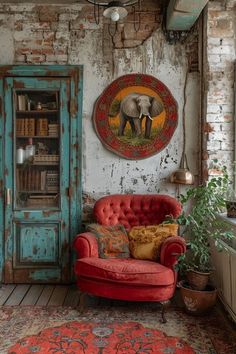 a living room with an elephant painting on the wall next to a red couch and chair