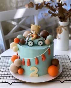 a teddy bear riding on top of a blue cake