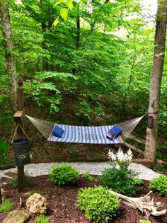 a hammock is set up in the middle of a wooded area with rocks and trees