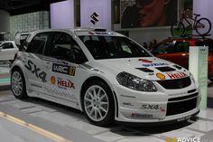 a white car is on display at an auto show