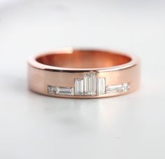 UNIQUE ROSE GOLD DIAMOND WEDDING BAND, BAGUETTE DIAMOND WEDDING RINGUnique baguette diamond band. The design can be made with gemstones of your choosing. If you would prefer a custom ring, please contact us before purchase.DETAILSMain Stone  Stone: Diamonds  Shape: Baguette  Color: F - G Color  Quality: Vs Clarity Side Stones  Baguette White Diamonds:  (2)  Baguette White Diamonds:  (2)  Princess White Diamonds:  (2) Band  Style: Other  Material:  14k Gold: yellow, white, rose  18k Gold: yellow, Wedding Band Baguette, Baguette Wedding Rings, Baguette Diamond Wedding Band, Baguette Wedding Band, Baguette Diamond Band, 2 Princess, Wedding Ring Unique, Unique Roses, Baguette Diamond Rings