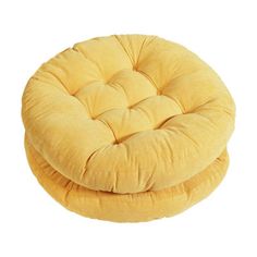 a yellow round chair cushion sitting on top of a white floor