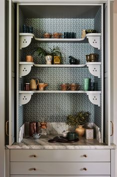 the shelves in this kitchen are filled with pots and pans