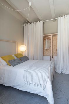 a white bed sitting under a window in a bedroom