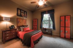 a bedroom with a bed, dressers and a basketball hoop on the wall above it