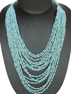 22" Double Twisting Turquoise Seed Beads Strand Layered NecklaceThis beautiful layered necklace is handbeaded. Each of the 16 layers are made of 2 twisting strands of seed beads. If you like opulent necklaces, this piece is for perfect for you.Bead Color:  TurquoiseBead Type:  Glass seed beadsNecklace Length:  22" (shortest strand)Necklace Weight:  ~4.5ozStrand Count:  32 Blue Beaded Multi-strand Layered Necklace, Blue Multi-strand Beaded Layered Necklace, Turquoise Beaded Multi-strand Layered Necklace, Turquoise Beaded Multi-strand Necklace, Multi-strand Polished Turquoise Beads, Turquoise Multi-strand Polished Beads, Adjustable Multi-strand Layered Beaded Necklace, Multi-strand Turquoise Gemstone Beads Necklace, Turquoise Faceted Multi-strand Beaded Necklaces