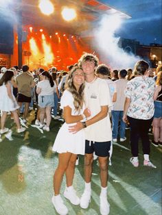 two people standing next to each other in front of a crowd at a music festival