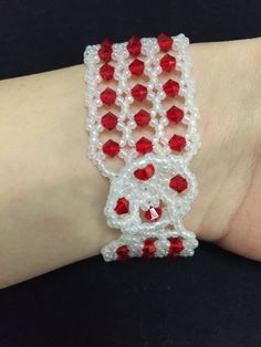 red and white beaded bracelet on someone's arm