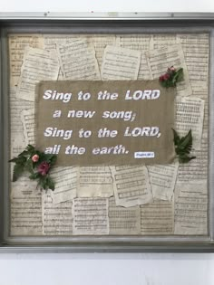 a framed piece of paper with words and flowers on it that reads, sing to the lord a new song, sing to the lord, all the earth