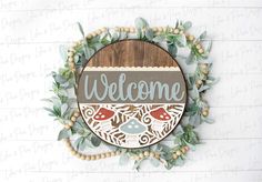 a welcome sign hanging from the side of a wooden plaque with leaves and berries around it