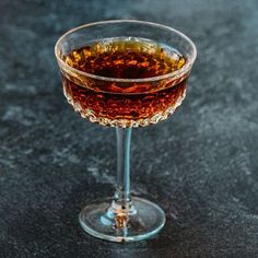 a glass filled with liquid sitting on top of a table