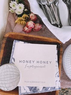 there are some flowers and silverware on the table next to each other, along with a sign that says honey honey