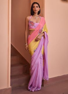 Introducing the stunning Multi Colour Embroidered Crepe Saree with Halter Blouse, crafted from luxurious crepe fabric. The multi colour saree features a vibrant blend of pastel hues – soft pink, sunny yellow, and lilac – creating a harmonious and eye-catching palette. The saree drapes beautifully for a sophisticated look and is adorned with intricate 3D embroidered floral bootas, adding a touch of elegance and charm to the ensemble. Paired with an embroidered halter blouse, this outfit perfectly Traditional Pink Pre-draped Saree With Floral Embroidery, Multicolor Georgette Blouse For Reception, Pink Embroidered Fitted Pre-draped Saree, Pink Floral Embroidered Pre-draped Saree For Wedding, Multicolor Blouse With Dupatta For Reception, Pink Fitted Georgette Pre-draped Saree, Designer Multicolor Georgette Blouse, Multicolor Georgette Blouse, Pink Pre-draped Saree With Floral Embroidery