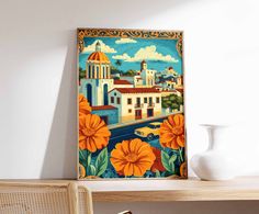 an orange flowered painting on the wall next to a white vase and wooden table