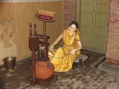 a woman is sitting on the floor using a machine to make something out of clay