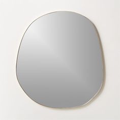 a round mirror on the wall with a white background