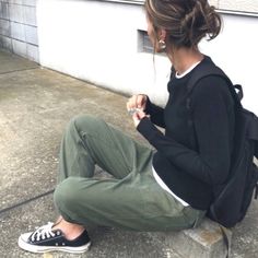 a woman sitting on the ground looking at her cell phone